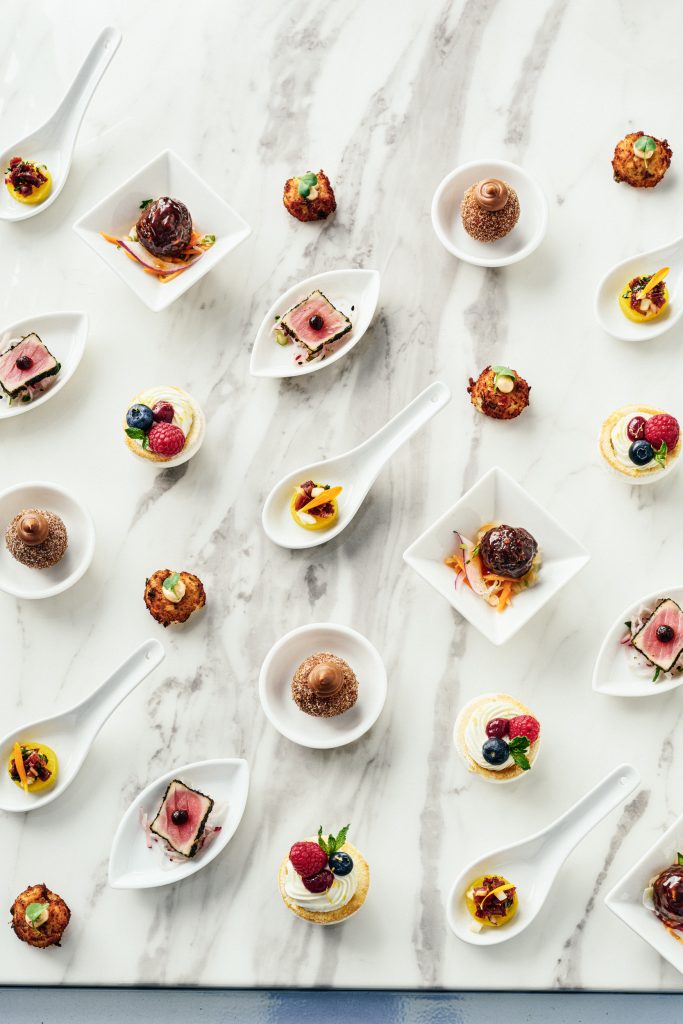 Various Hors d'Oeuvres served on different plates, bowls, and spoons.