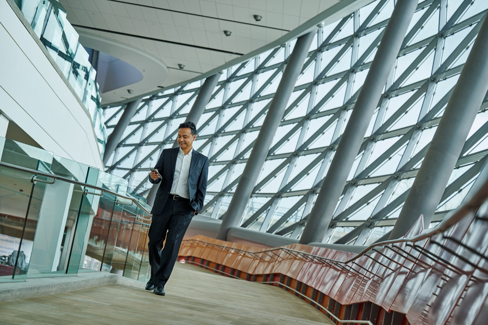 A man looks at his phone as he walks in the Shaw Centre.