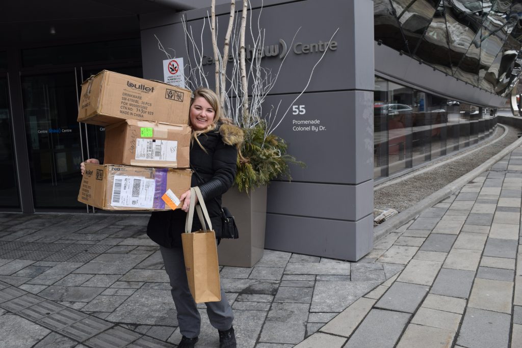 person holding boxes in front of shaw centre