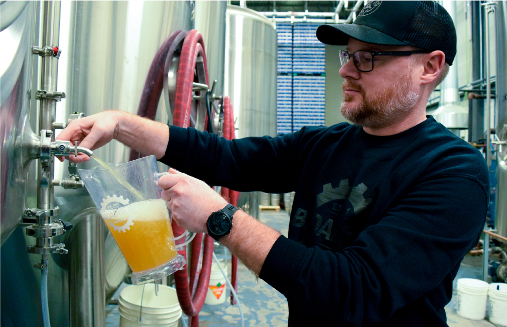 person pouring beer into pitcher