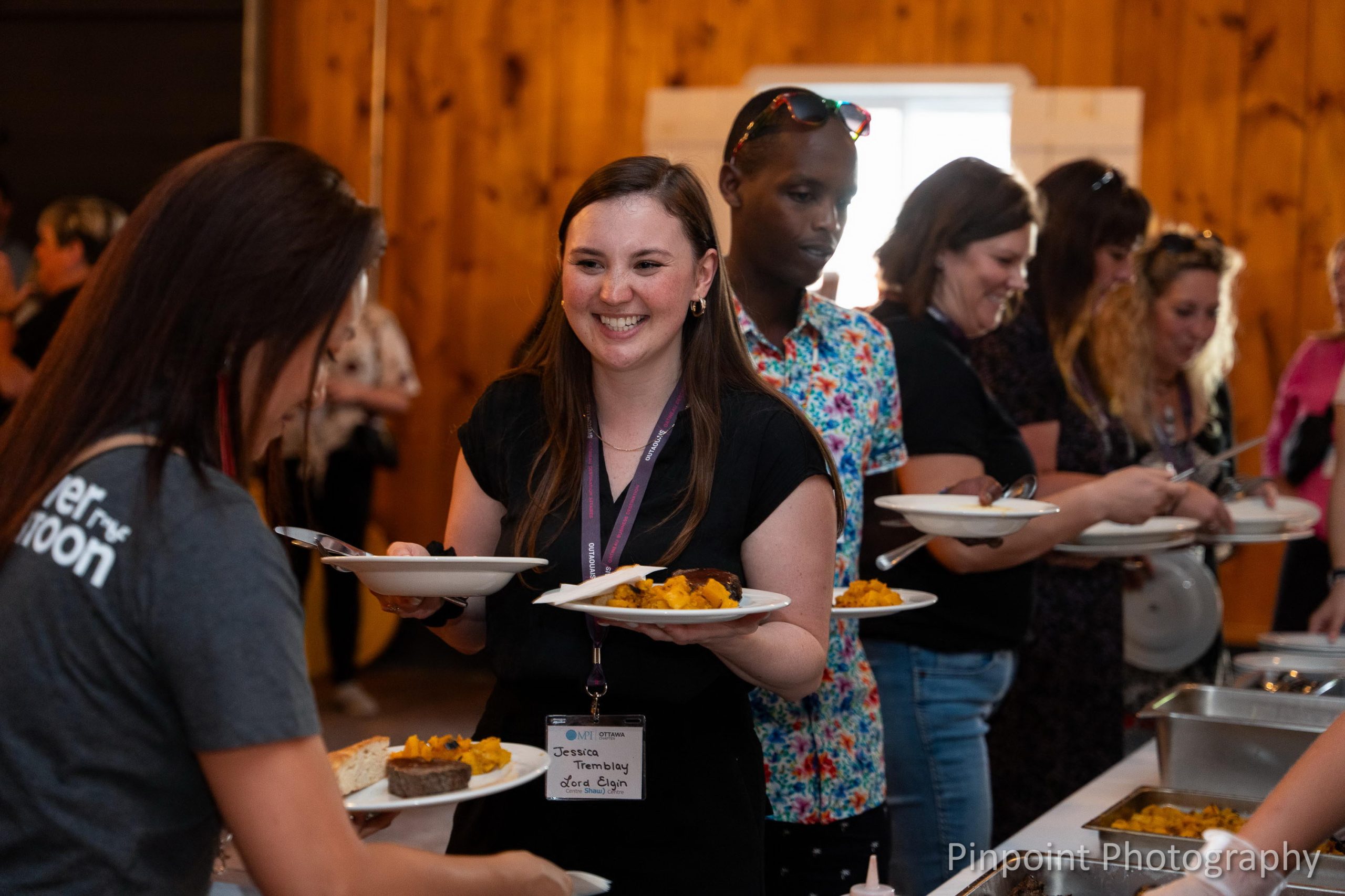 People grabbing food at the Mādahòkì Farm Dinner