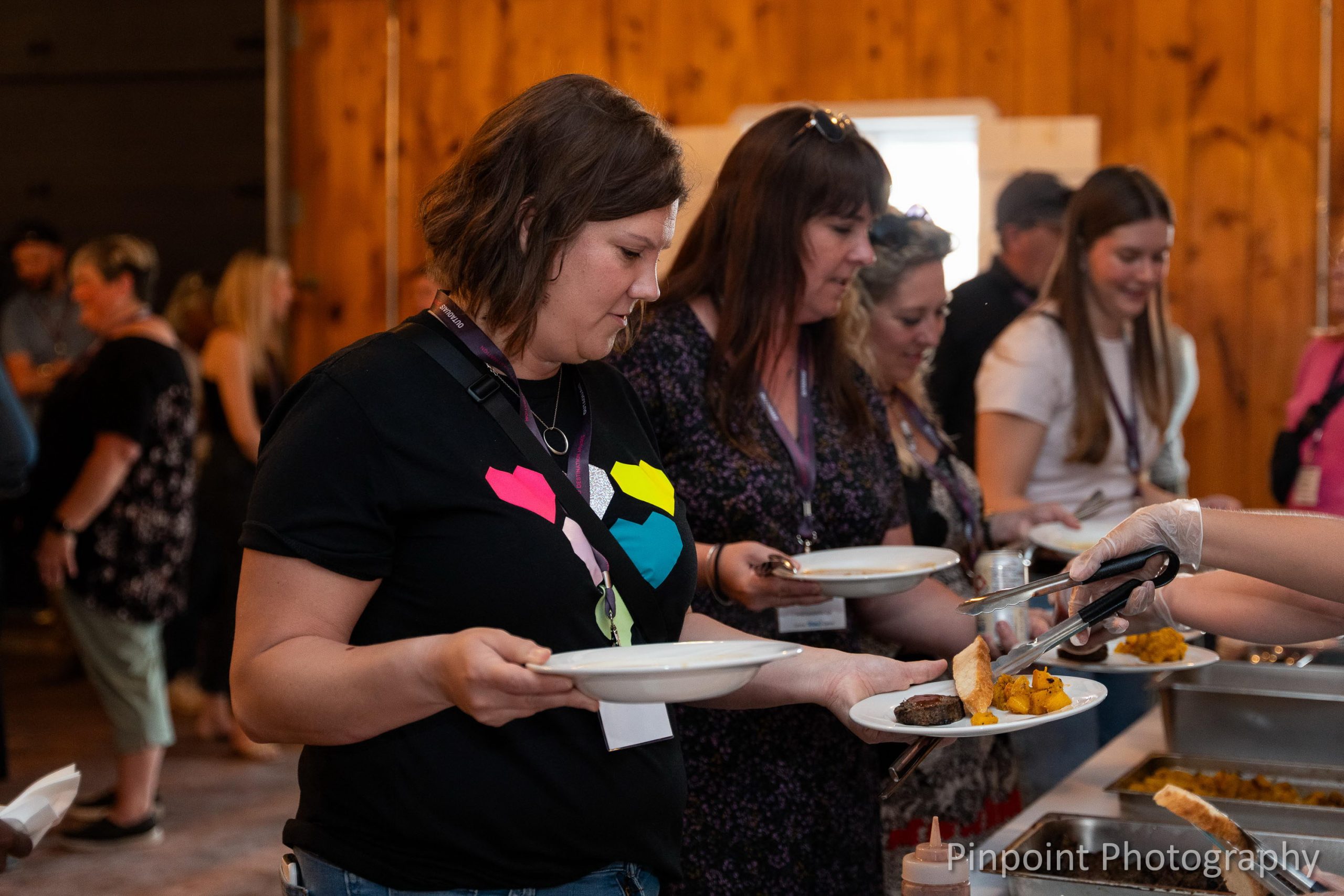 People getting served food at the Mādahòkì Farm Dinner