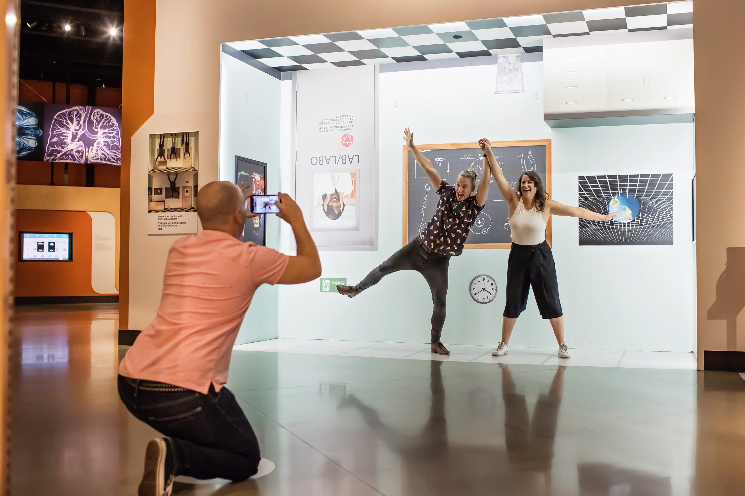 Guy taking a photo of a couple at the Science and Technology Museum