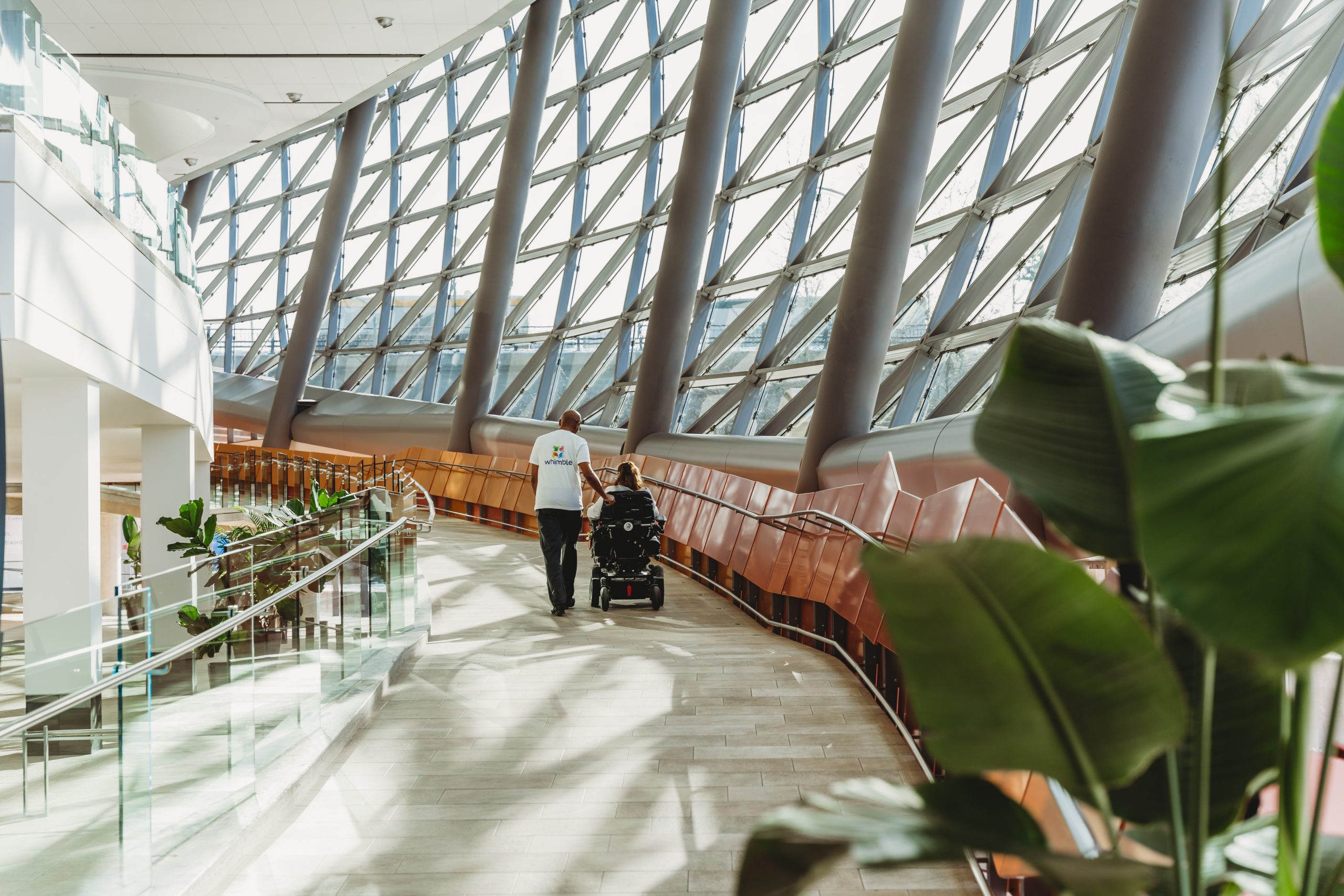 care attendant walking with person in wheelchair up a ramp at shaw centre